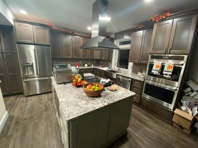 Espresso cabinet kitchen remodel with a granite island, stainless island hood, and double wall ovens by KRidge Construction