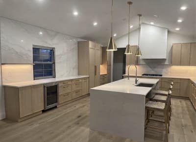 Modern Sewell, NJ kitchen remodel with light wood cabinetry, marble-look backsplash, and a quartz waterfall island by KRidge Construction